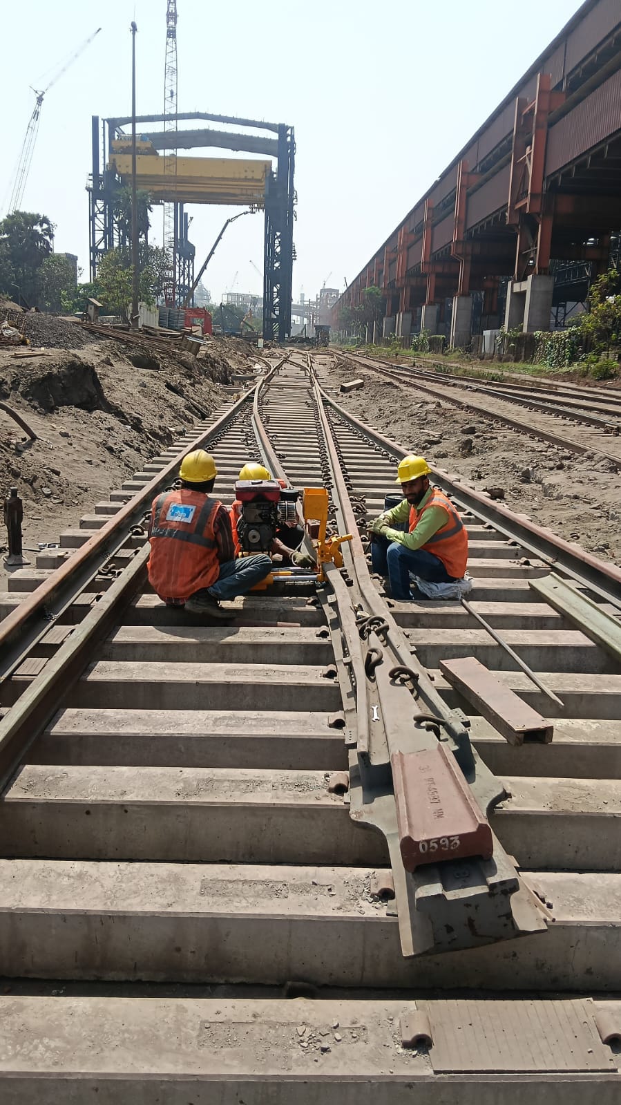 Crew installing crossover at industrial rail yard